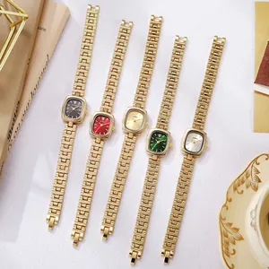 Montre dorée vintage élégante pour femme avec cadran carré sur surface en marbre