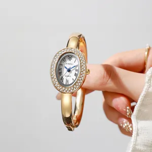 Macro view of oval bezel with double row rhinestones and blue hands on quartz watch