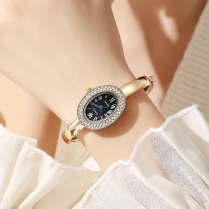Elegant gold oval bangle watch with rhinestone bezel and black Roman dial on wrist
