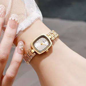 Gros plan d'une montre à chaîne dorée avec cadran carré sur le poignet d'une femme