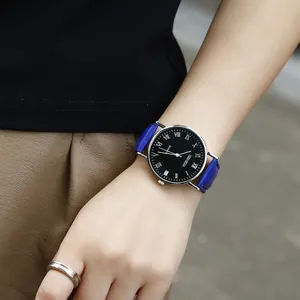 Detail shot of a business quartz watch with a blue leather strap and Roman numeral dial