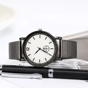 Minimalist quartz watch with white dial and grey mesh band on a business desk