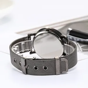 Minimalist quartz watch with dark grey steel mesh strap shown from a back perspective
