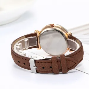 Détail du bracelet en cuir marron avec boîtier en or rose et boucle ardillon argentée