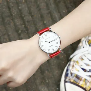 Macro view of casual Geneva quartz watch featuring a red leather strap and roman numeral dial