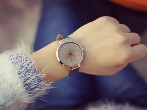 Gros plan d'une montre en or rose élégante avec cadran ciel étoilé et bracelet en cuir