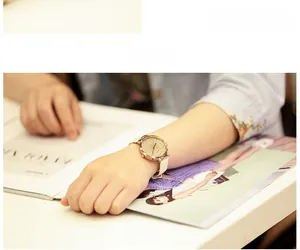 Gros plan d'une montre à quartz dorée pour femme avec bracelet en cuir blanc