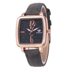 Detail of square rose gold watch with black starry dial and grey suede strap for women