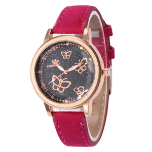 Détail d'une montre or rose avec cadran papillon étoilé et bracelet en suède fuchsia