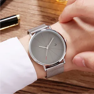 Minimalist men's quartz watch with gray radial dial and silver mesh strap on wooden table