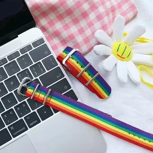 Détail d'un bracelet de montre NATO en nylon rayé arc-en-ciel avec boucle métallique