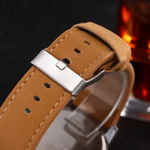Detail of camel brown frosted leather watch strap with silver buckle and fine stitching