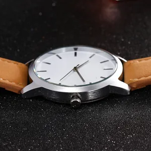 Detailed close-up of silver brushed steel watch case and tan leather strap stitching