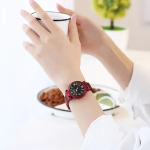 Nahaufnahme einer Damen-Quarzuhr mit rotem Sternenhimmel und Mesh-Armband am Handgelenk