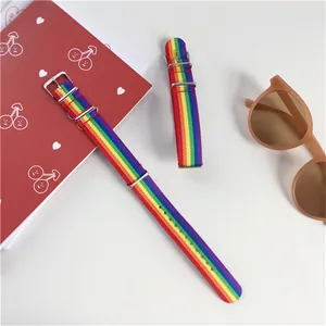 Bracelet de montre arc-en-ciel en nylon avec boucle en acier sur un bureau blanc épuré