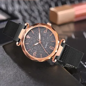 Detalle de reloj de cuarzo en oro rosa con esfera de cielo estrellado negro y malla milanesa