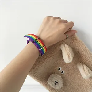 Gros plan du bracelet de montre en nylon arc-en-ciel avec boucle en métal sur le poignet