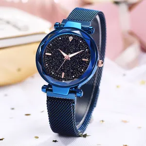 Close-up of starry sky dial and faceted glass case on a blue magnetic mesh watch