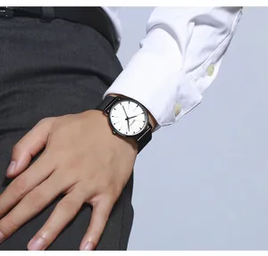 Gros plan d'une montre Geneva noire minimaliste avec cadran blanc au poignet d'un homme