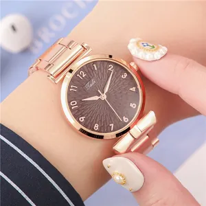Detail van roségoud quartz horloge met donkerbruine bloemenwijzerplaat en strikband