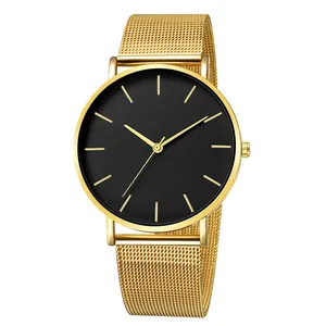 Close-up of minimalist black dial watch with gold indices and Milanese mesh strap