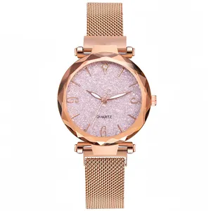 Detalle de reloj con correa de malla oro rosa, cristal facetado y esfera rosa brillante