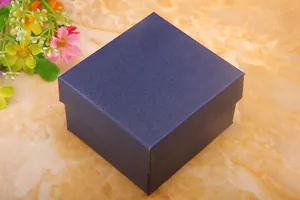 Detail of square navy blue jewelry box with horizontal stripes on marble background