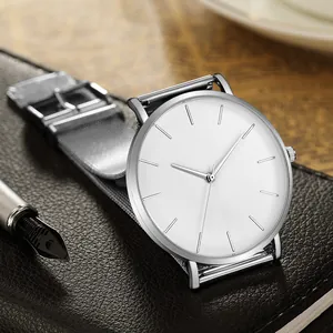 Minimalist silver quartz watch with white dial on black leather notebook with a pen