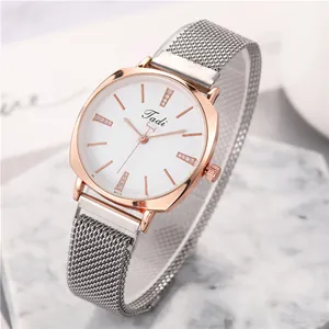 Close-up of Tadi rose gold square watch with silver mesh strap on marble base