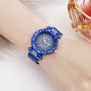 Blue floral dial ladies watch with rhinestone accents and magnetic milanese strap on wrist