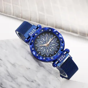 Detailed close-up of blue mesh band watch with rhinestone flower dial on marble