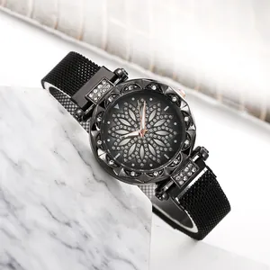 Women's black Milanese loop watch with rhinestone floral dial on marble surface
