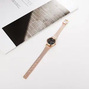 Dettaglio del cinturino in maglia oro rosa e quadrante stellato dell'orologio al quarzo