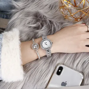 Close-up of elegant silver ladies watch set with rhinestone bezel on plush background