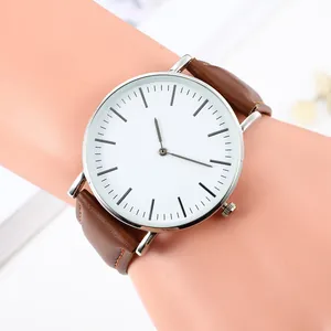 Minimalist quartz watch with white dial, silver case and brown leather strap on wrist