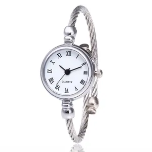 Minimalist women's silver bangle watch featuring a white Roman dial and cable strap