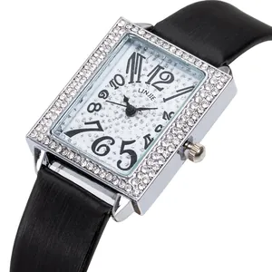 Macro shot of rectangular silver watch case with double-row rhinestones and art deco numerals
