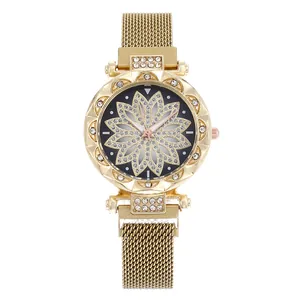 Detailed macro view of gold-tone floral dial with sparkling rhinestones on mesh watch band