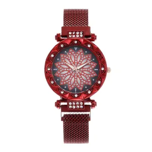 Detail of red women's quartz watch featuring a crystal flower dial and magnetic mesh strap