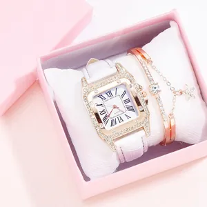 Close-up of gold square diamond watch with white leather strap in pink gift box