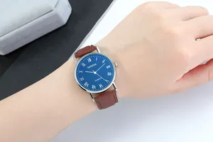 Close-up of Geneva men's quartz watch with blue dial and brown leather strap on wrist