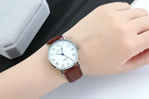 Detail of Geneva quartz watch with blue hands and brown leather strap on wrist