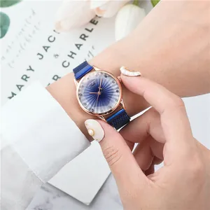Montre femme avec cadran bleu étoilé et bracelet magnétique rose doré sur le poignet