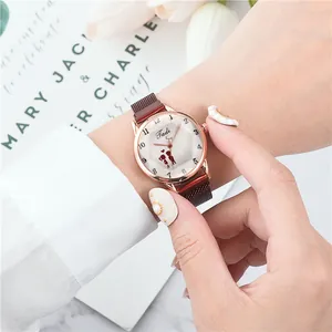 Dettaglio dell'orologio in oro rosa con cinturino magnetico bordeaux indossato al polso