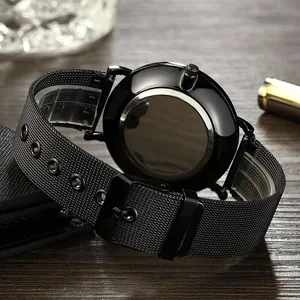 Reloj minimalista negro de malla de acero inoxidable sobre fondo de madera oscura