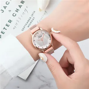 Detail einer roségoldenen Quarzuhr mit Magnetarmband und Zifferblatt mit Herz