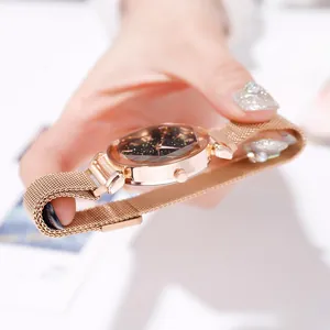 Dettaglio dell'orologio da donna con quadrante stellato e cinturino mesh rosa