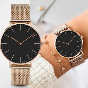 Minimalist rose gold mesh strap watch with large black dial shown on female wrist