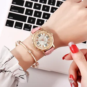 Women's gold watch with pink leather strap and matching star bracelet on wrist