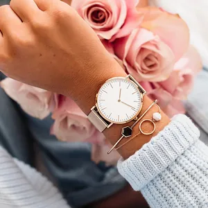Rose gold mesh watch with minimalist white dial and matching layered bracelets set